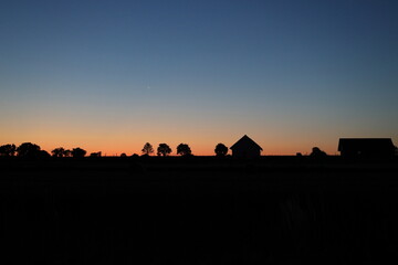 Sunset, shadows of houses and trees, moon and sky