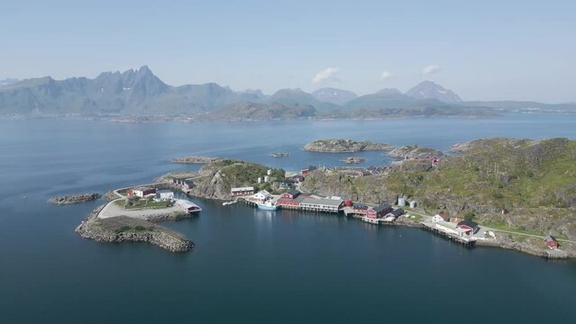 un village norv&eacute;gien au bord de la mer avec une chaine de montagne en arri&egrave;re plan