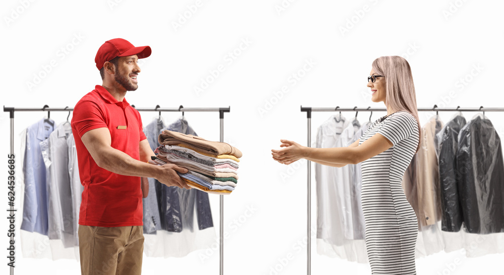 Wall mural Man delivering a pile of folded clothes to a young woman at the dry cleaners