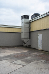 Fototapeta na wymiar Ventilation duct exiting a warehouse and venting on the roof.