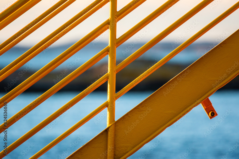 Wall mural Yellow metal hand railings on a ferry.