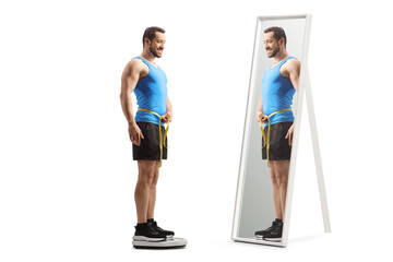 Full length shot of a fit man in sportswear measuring waist and standing on a weight scale in front of a mirror