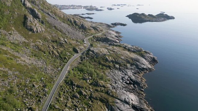 une route qui longe une montagne au bord de la mer arctique