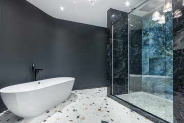The brutal design of the bathroom, decorated in gray and white. The shower cabin is .decorated with black marble tiles.
