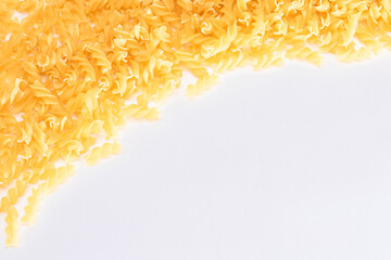 Uncooked Fusilli Pasta with Copy Space on White Background. Raw and Dry Macaroni. Fat and Unhealthy...