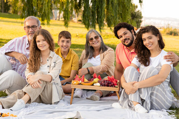 Cheerful caucasian multi-generation people have rest, enjoy picnic, meal and weekend