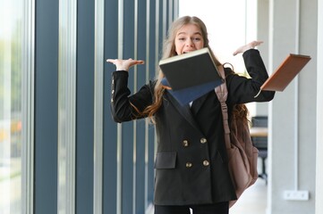 Emotional student girl within walls of institute celebrating successful exam pass, high school or college admission, european employee raised hands feels happy by salary growth, got promoted concept