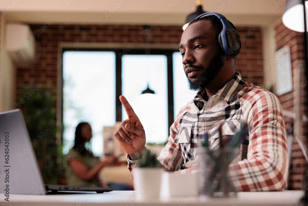 Poster african american student with wireless headphones in online video conference lesson pointing up doin