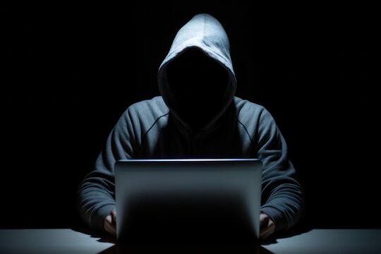Anonymous Hacker by Laptop in a Dark Room 