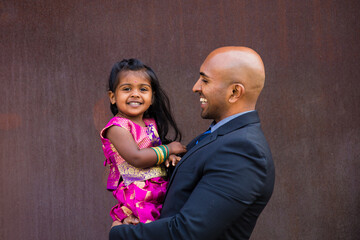beautiful indian family dad father with daughter girl hugging and smiling with a bindi and...