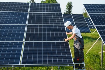 Worker installing solar panels outdoors.