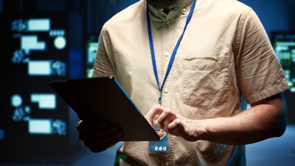 Engineer in data center setting up high bandwidth dedicated multiplayer online gaming servers to accommodate more traffic from worldwide locations, avoid disruptive lag times and low ping rates