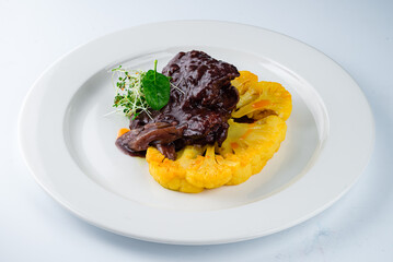 Healthy food beef fillet steak in sauce with cauliflower and microgreens.