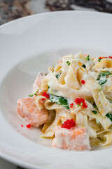 Linguini pasta with salmon, spinach, cream sauce, caviar and microgreens.