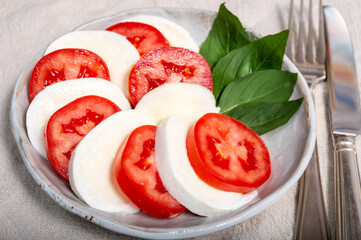 Itaian vegetarian food, fresh caprese salad made with white soft italian mozzarella cheese, red tomato and green basil with olive oil