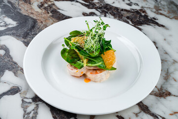 Dinner king prawns in cream sauce with oranges, spinach and microgreens.