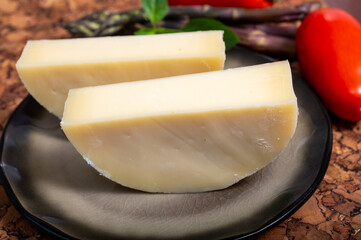 Italian cheese, Provolone dolce cow cheese from Cremona served with olive bread and tomatoes close up