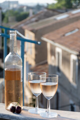 French cold rose dry wine from Provence in two glasses in sunny day with view on old roofs of Arles town