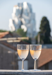 French cold rose dry wine from Provence in two glasses in sunny day with view on old roofs of Arles town