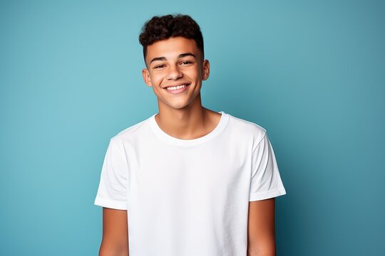 smiling young man in white shirt against blue background,