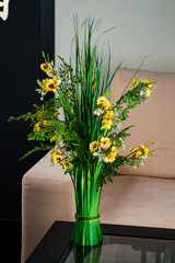 Bouquet of artificial yellow flowers on the table.