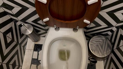 A man urinates in the toilet while standing. A person stands in a modern toilet and urinates in the first person. the stream of urine flies straight into the toilet opening. Modern repair of the toile