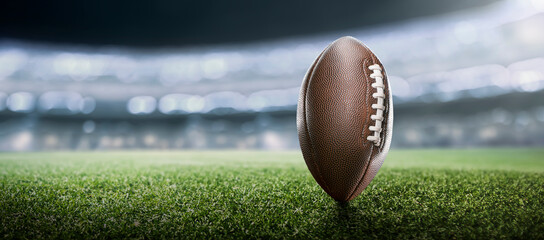 American football ball on the grass of a stadium in a game