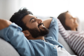 Satisfied eastern young spouses resting at home