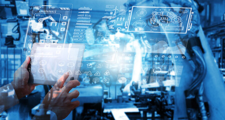Digital future manufacture concept, Industrial Engineer working with automation robot arms machine  on real time monitoring system software.