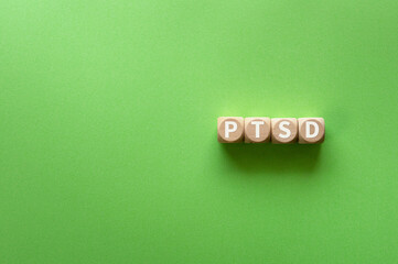 There is wood cube with the word PTSD. It is an abbreviation for Post-Traumatic Stress Disorder as eye-catching image.