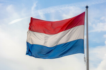 Fototapeta na wymiar National flag of the Netherlands with horizontal tricolour of red, white and blue, Dutch flag waving on the air in a sunny day as background.