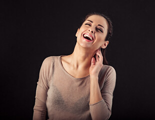 Beautiful excited laughing makeup woman with brown healthy hair looking up with open mouth and holding the face the hands. Closeup portrait