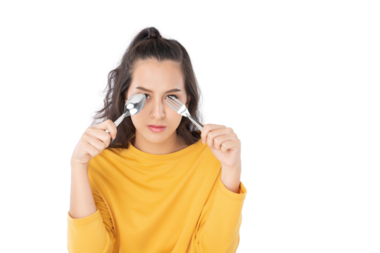 Young beauty Asian woman showing spoon and fork prepare to eat food and she wearing a yellow sweater shot isolated on white background