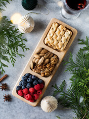 Berries and nuts in a wooden menagerie on a Christmas holiday table. Celebrating the new year, Christmas recipes.