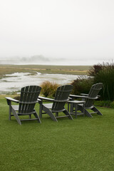 Adirondack chairs on lawn overlooking the foggy coast