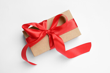 Beautiful gift box with red bow on white background, top view