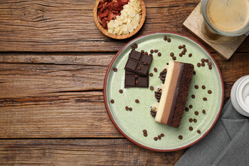 Tasty chocolate mousse cake and ingredients on wooden table, flat lay. Space for text