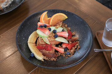 French toasts with blueberries, raspberries, banana, orange, maple syrup and coffee. morning breakfast.