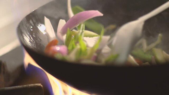 Assorted vegetables stir-fried in wok,
over fire, delicious, Peruvian Chinese food style, Slow motion