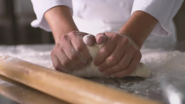 Hands kneading dough in pastry kitchen, Slow motion