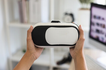 Close up hand holding realistic VR camera with office room background