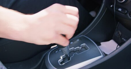 Male driver confidently shifts speed on automatic transmission. Close-up hand holding gear lever, changes speed. Obtaining a license, learning to drive confidently safely, extreme driving, test