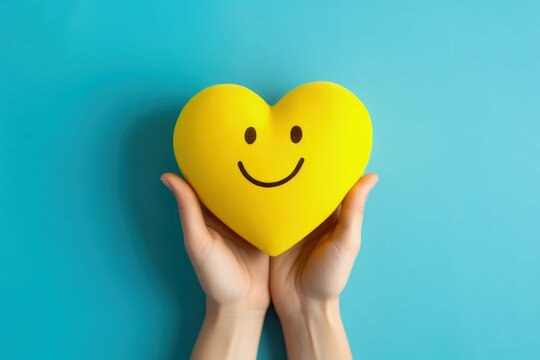 Hand holding heart shaped smiley emoji isolated on blue background, Generative AI