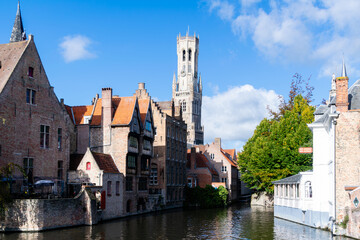 Fototapeta na wymiar Characteristic view of the canals of Bruges. In the background, the belfry (belfort) stands out. Belgium