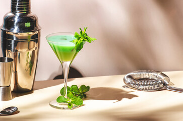 Grasshopper cocktail, green alcoholic drink with mint liqueur, cream, ice and fresh mint. Beige...