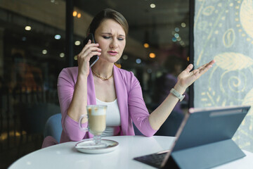 Upset young caucasian business woman emotionally talking on smartphone, bad news.