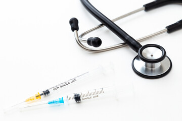 白背景に聴診器と注射器