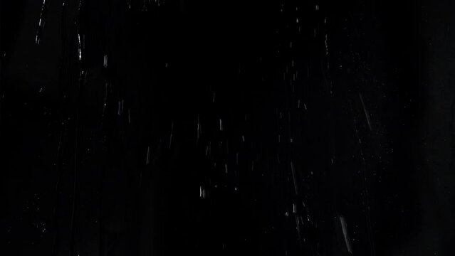 Transparent liquid splashing on a surface on a black background