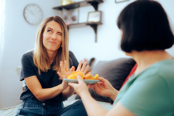 Daughter Refusing her Mom Trying to Overfeed her. Mother overfeeding her adult daughter when she...