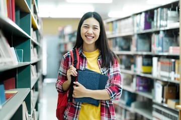Portrait of a Smart Beautiful Asian Girl Holding Study Text Books Smiling Looking at Camera.